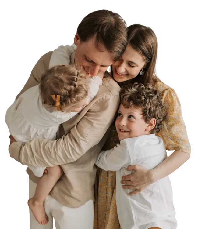 Happy family with parents hugging their young son and daughter closely during a supportive Parent Coaching journey.